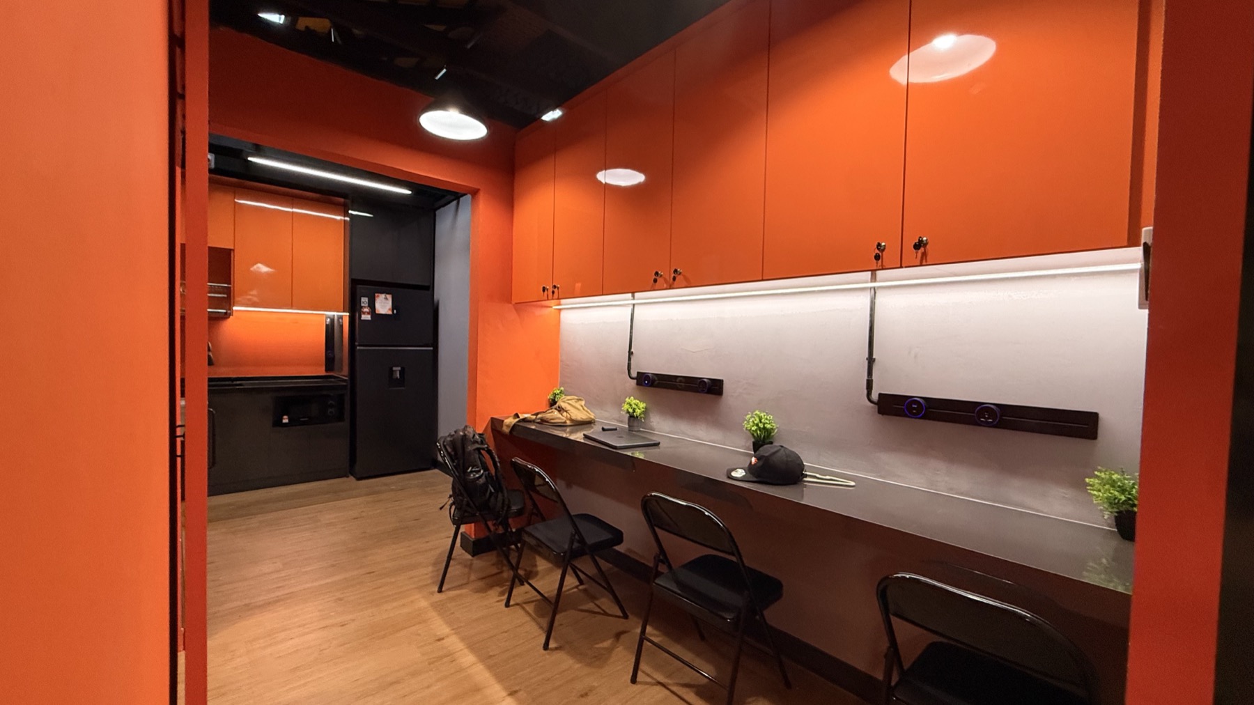 Lounge area in LEGACY+ with chairs, counter, and warm orange cabinetry.